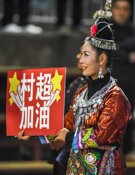 1月7日,一位村民手举“村超加油”的标牌 新华社记者 陶亮 摄